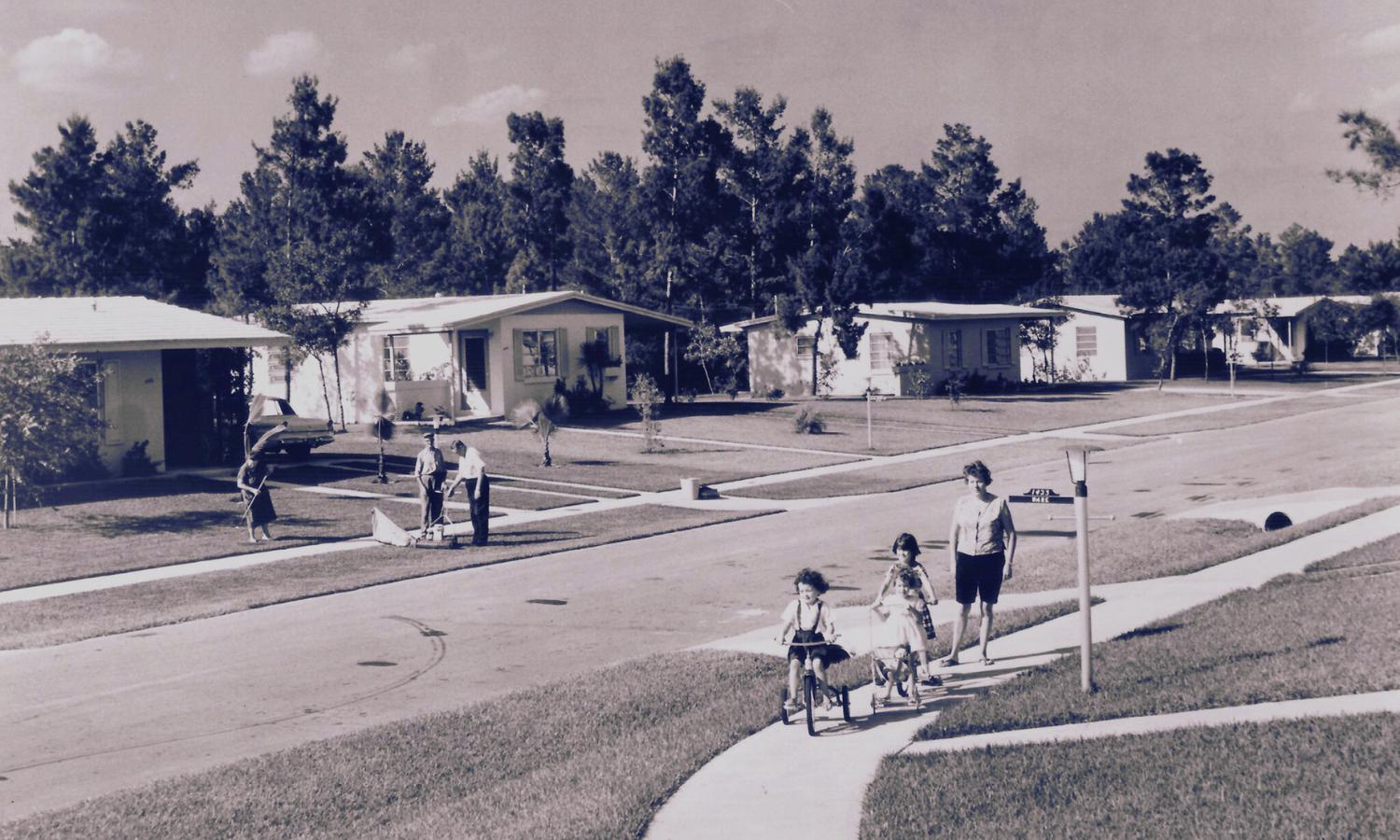 Vintage midcentury photo of Deltona: children on bikes, curving sidewalks, ranch homes, and manicured lawns