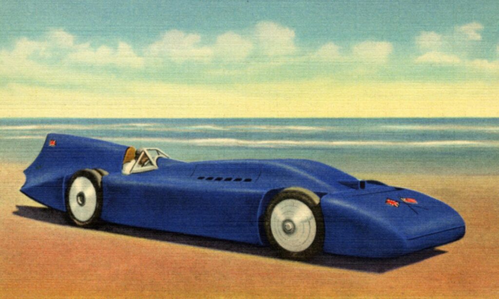 Vintage postcard illustration of a streamlined blue land-speed racing car on the hard-packed sands of Daytona Beach, capturing the early motorsports era that established Volusia County as the birthplace of speed and continues to inspire writers drawn to Florida’s racing history and coastal legend.